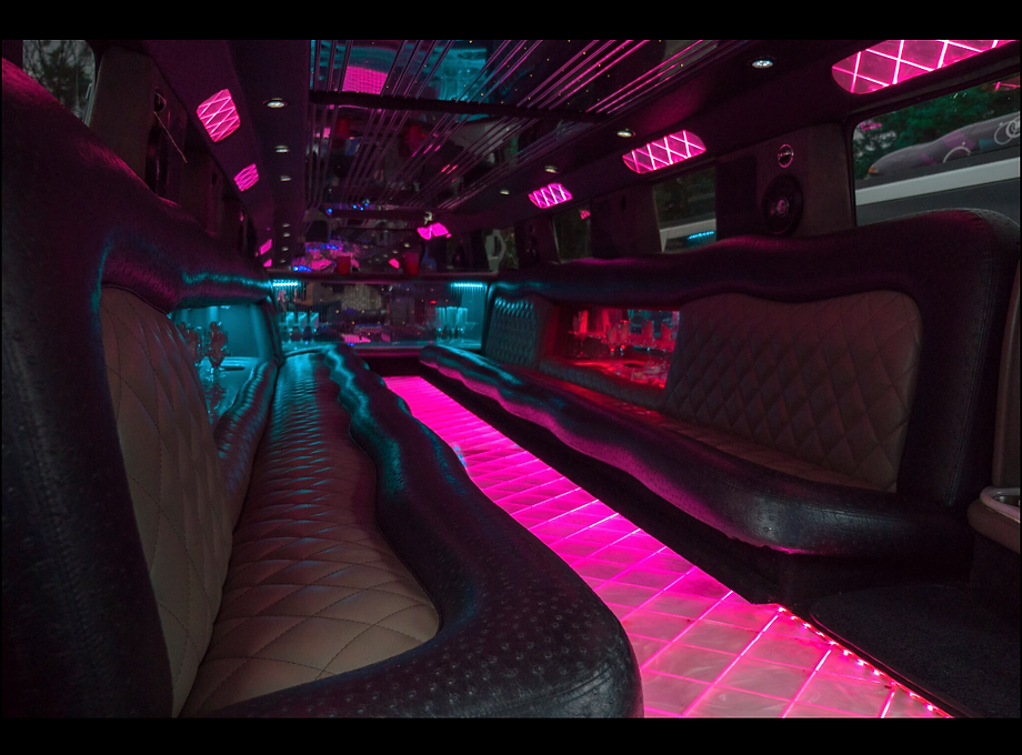 Interior of 20-passenger Hummer Limo with elegant decor, wrap-around seating, and a built-in bar